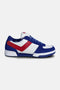 Linebacker trainer side view in white, navy and red – white mesh upper with navy suede overlays and rugged turf outsole.